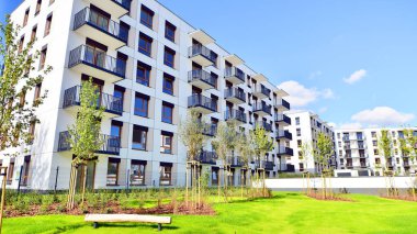 Bereketli yeşil ağaçlarla çevrili ve güneşli bir günde taze bitki örtüsüyle çevrili bir yerleşim yeri. Çağdaş mimari konut kompleksi yeşilliklerle çevrili.