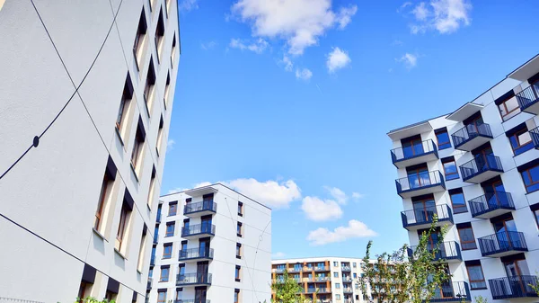 Bereketli yeşil ağaçlarla çevrili ve güneşli bir günde taze bitki örtüsüyle çevrili bir yerleşim yeri. Çağdaş mimari konut kompleksi yeşilliklerle çevrili.