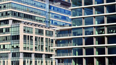 Gökyüzüne karşı birçok penceresi olan modern ofis binası manzarası. Cam cephe duvarı..