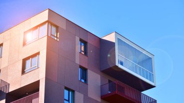 Modern lüks konut dairesi. Güneşli bir günde modern apartman binası. Mavi gökyüzü olan bir apartman. Modern bir apartmanın cephesi.