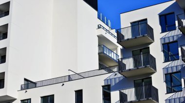 Modern lüks konut dairesi. Güneşli bir günde modern apartman binası. Mavi gökyüzü olan bir apartman. Modern bir apartmanın cephesi.