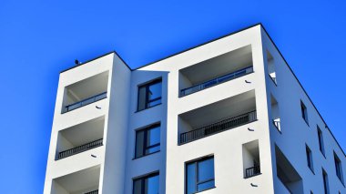 Modern lüks konut dairesi. Güneşli bir günde modern apartman binası. Mavi gökyüzü olan bir apartman. Modern bir apartmanın cephesi.
