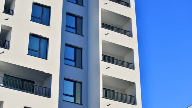 Modern lüks konut dairesi. Güneşli bir günde modern apartman binası. Mavi gökyüzü olan bir apartman. Modern bir apartmanın cephesi.