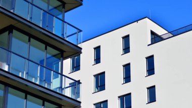 Modern lüks konut dairesi. Güneşli bir günde modern apartman binası. Mavi gökyüzü olan bir apartman. Modern bir apartmanın cephesi.