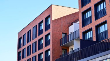 Modern lüks konut dairesi. Güneşli bir günde modern apartman binası. Mavi gökyüzü olan bir apartman. Modern bir apartmanın cephesi.