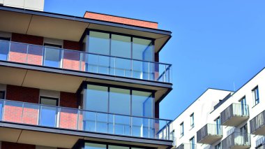 Modern lüks konut dairesi. Güneşli bir günde modern apartman binası. Mavi gökyüzü olan bir apartman. Modern bir apartmanın cephesi.