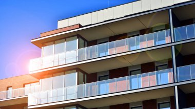 Modern lüks konut dairesi. Güneşli bir günde modern apartman binası. Mavi gökyüzü olan bir apartman. Modern bir apartmanın cephesi.