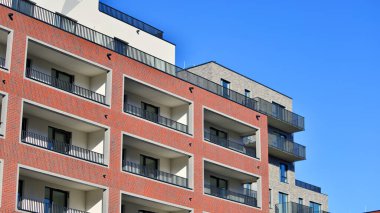 Modern lüks konut dairesi. Güneşli bir günde modern apartman binası. Mavi gökyüzü olan bir apartman. Modern bir apartmanın cephesi.