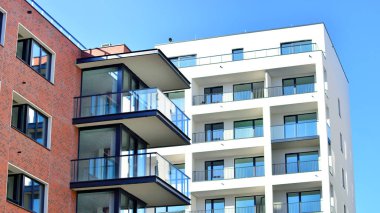 Modern lüks konut dairesi. Güneşli bir günde modern apartman binası. Mavi gökyüzü olan bir apartman. Modern bir apartmanın cephesi.