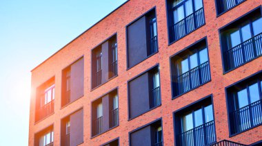 Modern lüks konut dairesi. Güneşli bir günde modern apartman binası. Mavi gökyüzü olan bir apartman. Modern bir apartmanın cephesi.