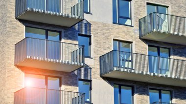 Modern lüks konut dairesi. Güneşli bir günde modern apartman binası. Mavi gökyüzü olan bir apartman. Modern bir apartmanın cephesi.