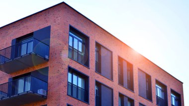 Modern lüks konut dairesi. Güneşli bir günde modern apartman binası. Mavi gökyüzü olan bir apartman. Modern bir apartmanın cephesi.