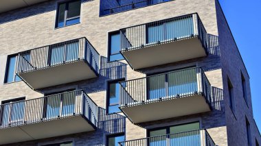 Modern lüks konut dairesi. Güneşli bir günde modern apartman binası. Mavi gökyüzü olan bir apartman. Modern bir apartmanın cephesi.