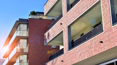 Modern lüks konut dairesi. Güneşli bir günde modern apartman binası. Mavi gökyüzü olan bir apartman. Modern bir apartmanın cephesi.