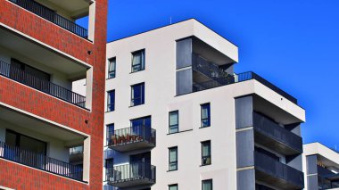 Modern lüks konut dairesi. Güneşli bir günde modern apartman binası. Mavi gökyüzü olan bir apartman. Modern bir apartmanın cephesi.