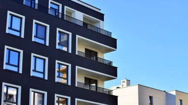 Modern lüks konut dairesi. Güneşli bir günde modern apartman binası. Mavi gökyüzü olan bir apartman. Modern bir apartmanın cephesi.