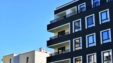 Modern lüks konut dairesi. Güneşli bir günde modern apartman binası. Mavi gökyüzü olan bir apartman. Modern bir apartmanın cephesi.