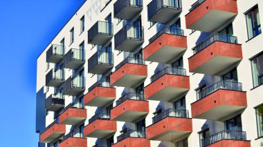 Modern lüks konut dairesi. Güneşli bir günde modern apartman binası. Mavi gökyüzü olan bir apartman. Modern bir apartmanın cephesi.