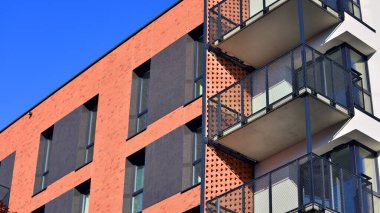 Modern lüks konut dairesi. Güneşli bir günde modern apartman binası. Mavi gökyüzü olan bir apartman. Modern bir apartmanın cephesi.