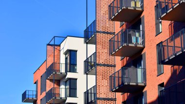 Modern lüks konut dairesi. Güneşli bir günde modern apartman binası. Mavi gökyüzü olan bir apartman. Modern bir apartmanın cephesi.