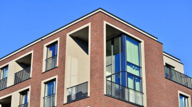 Modern lüks konut dairesi. Güneşli bir günde modern apartman binası. Mavi gökyüzü olan bir apartman. Modern bir apartmanın cephesi.