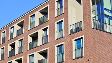 Modern lüks konut dairesi. Güneşli bir günde modern apartman binası. Mavi gökyüzü olan bir apartman. Modern bir apartmanın cephesi.