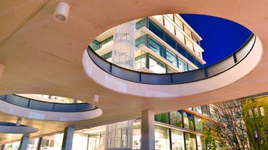 Şehir merkezindeki modern ofis binası gece aydınlandı. Aydınlatılmış pencereler modern bir cephenin mimari şebekesine karşı. Gece versiyonunda beton ve cam cephe.