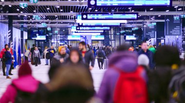 Varşova, Polonya. 28 Kasım 2025. Warszawa Zachodnia tren istasyonundaki yeraltı koridorundan geçecekler. Tavan büyük bir yapay aydınlatmaya monte edilmiş..