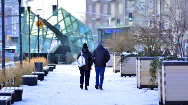 Varşova, Polonya. 5 Ocak 2026. Soğuk bir kış gününde şehirde sokakta yürüyen insanlar var. Kalabalık kalabalık caddede yürüyen isimsiz insanlar. Şehir sokak hayatı.