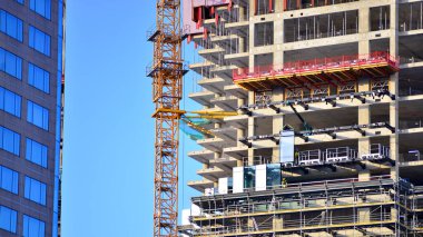 Varşova, Polonya. 5 Ocak 2026. Yukarı Bir gökdelenin inşaatı. Şehirdeki yüksek binaların arasında bir vinç..