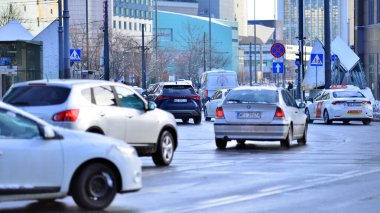 Varşova, Polonya. 5 Ocak 2026. Kış günü şehir merkezinde yol trafiği. Şehir merkezindeki trafik, binalar ve gökdelenlerle dolu bir caddeyi bir kış günü görmek.