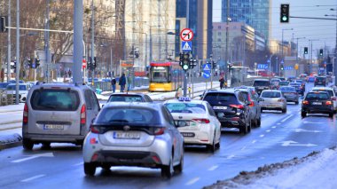 Varşova, Polonya. 5 Ocak 2026. Kış günü şehir merkezinde yol trafiği. Şehir merkezindeki trafik, binalar ve gökdelenlerle dolu bir caddeyi bir kış günü görmek.