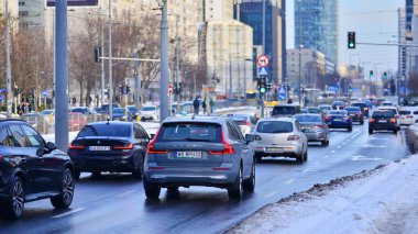Varşova, Polonya. 5 Ocak 2026. Kış günü şehir merkezinde yol trafiği. Şehir merkezindeki trafik, binalar ve gökdelenlerle dolu bir caddeyi bir kış günü görmek.