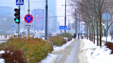Varşova, Polonya. 15 Ocak 2026. Soğuk bir kış gününde şehirde sokakta yürüyen insanlar var. Kalabalık kalabalık caddede yürüyen isimsiz insanlar. Şehir sokak hayatı.