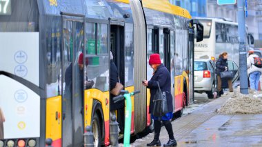 Varşova, Polonya. 15 Ocak 2026. Otobüs durağı. Yolcular otobüse biner ve inerler.