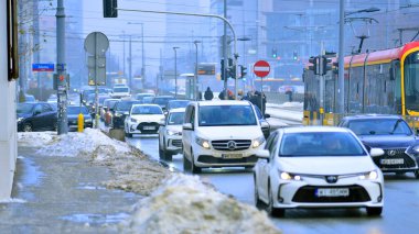 Varşova, Polonya. 15 Ocak 2026. Kış günü şehir merkezinde yol trafiği. Bir kış günü şehir merkezinde trafik ve binaların olduğu bir cadde manzarası.
