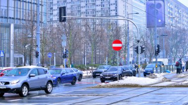 Varşova, Polonya. 15 Ocak 2026. Kış günü şehir merkezinde yol trafiği. Bir kış günü şehir merkezinde trafik ve binaların olduğu bir cadde manzarası.
