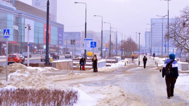 Varşova, Polonya. 15 Ocak 2026. Soğuk bir kış gününde şehirde sokakta yürüyen insanlar var. Kalabalık kalabalık caddede yürüyen isimsiz insanlar. Şehir sokak hayatı.