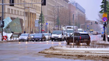 Varşova, Polonya. 15 Ocak 2026. Kış günü şehir merkezinde yol trafiği. Bir kış günü şehir merkezinde trafik ve binaların olduğu bir cadde manzarası.