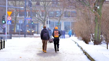 Varşova, Polonya. 15 Ocak 2026. Soğuk bir kış gününde şehirde sokakta yürüyen insanlar var. Kalabalık kalabalık caddede yürüyen isimsiz insanlar. Şehir sokak hayatı.