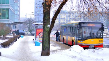 Varşova, Polonya. 15 Ocak 2026. Otobüs durağı. Yolcular otobüse biner ve inerler.