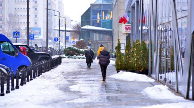 Varşova, Polonya. 15 Ocak 2026. Soğuk bir kış gününde şehirde sokakta yürüyen insanlar var. Kalabalık kalabalık caddede yürüyen isimsiz insanlar. Şehir sokak hayatı.