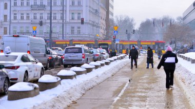 Varşova, Polonya. 15 Ocak 2026. Soğuk bir kış gününde şehirde sokakta yürüyen insanlar var. Kalabalık kalabalık caddede yürüyen isimsiz insanlar. Şehir sokak hayatı.