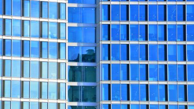 Çelik ve camdan yapılmış modern bir bina, konut ofisleri ve finans kurumları. Binanın ön cephesinde cam duvar var..