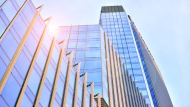 Çelik ve camdan yapılmış modern ofis binası. Ofis binasının pencereleri. Güneş ışığıyla soyut mimari kavram.