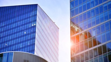 Çelik ve camdan yapılmış modern ofis binası. Ofis binasının pencereleri. Güneş ışığıyla soyut mimari kavram.