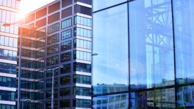 Çelik ve camdan yapılmış modern ofis binası. Ofis binasının pencereleri. Güneş ışığıyla soyut mimari kavram.
