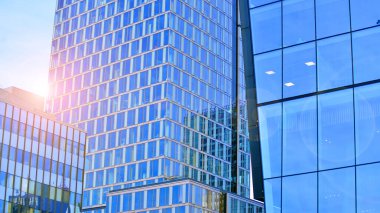 Çelik ve camdan yapılmış modern ofis binası. Ofis binasının pencereleri. Güneş ışığıyla soyut mimari kavram.