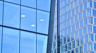 Çelik ve camdan yapılmış modern bir bina, konut ofisleri ve finans kurumları. Binanın ön cephesinde cam duvar var..