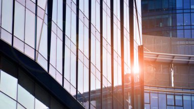 Çelik ve camdan yapılmış modern ofis binası. Ofis binasının pencereleri. Güneş ışığıyla soyut mimari kavram.